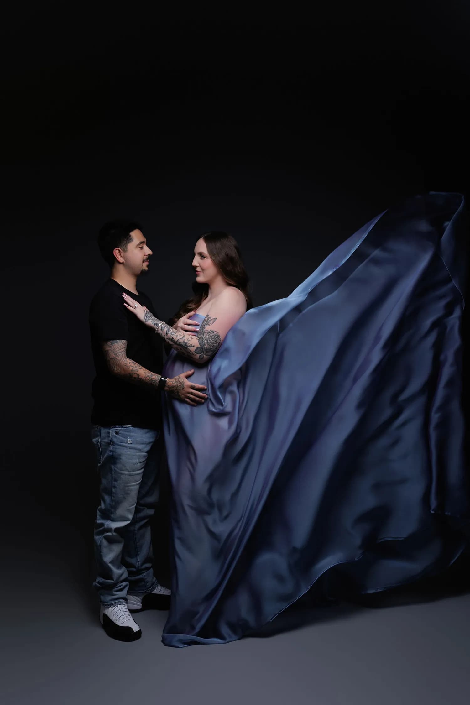 Couple facing each other, the pregnant woman in flowing blue satin